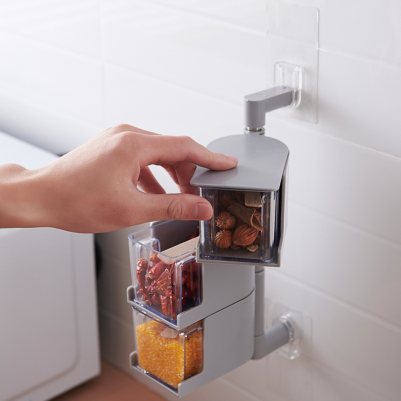 Hand pulling a transparent seasoning drawer out of the wall-mounted unit