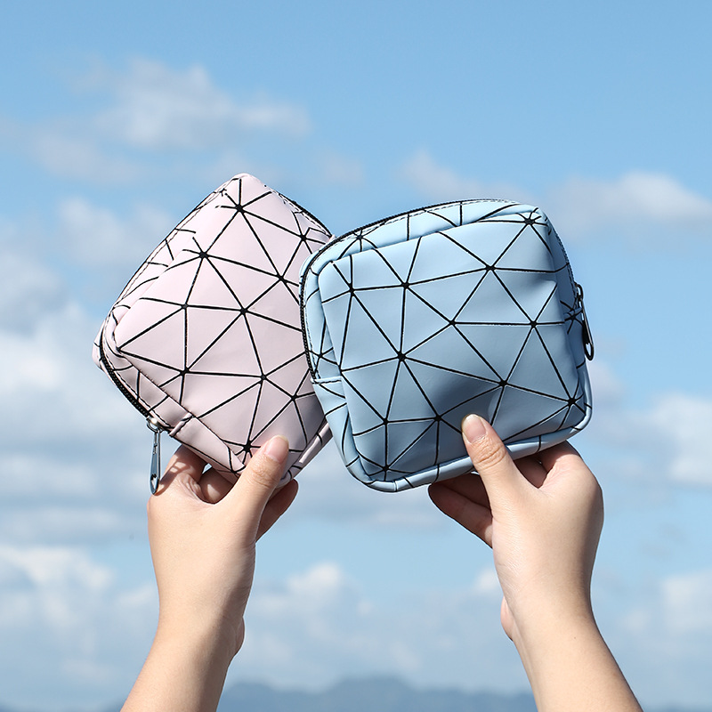 Two geometric pouches in pink and light blue against a clear sky