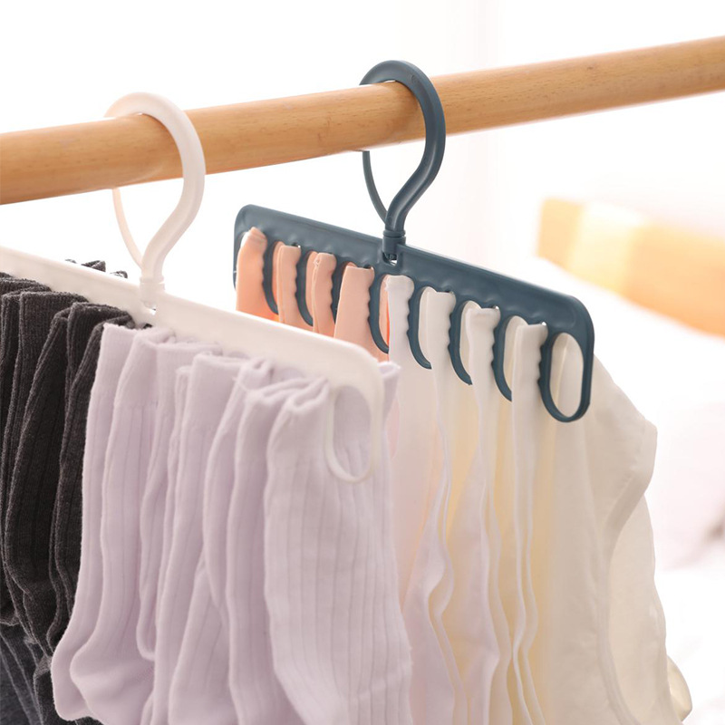Two hangers on a wooden rail, one white and one slate teal, with swivel hooks