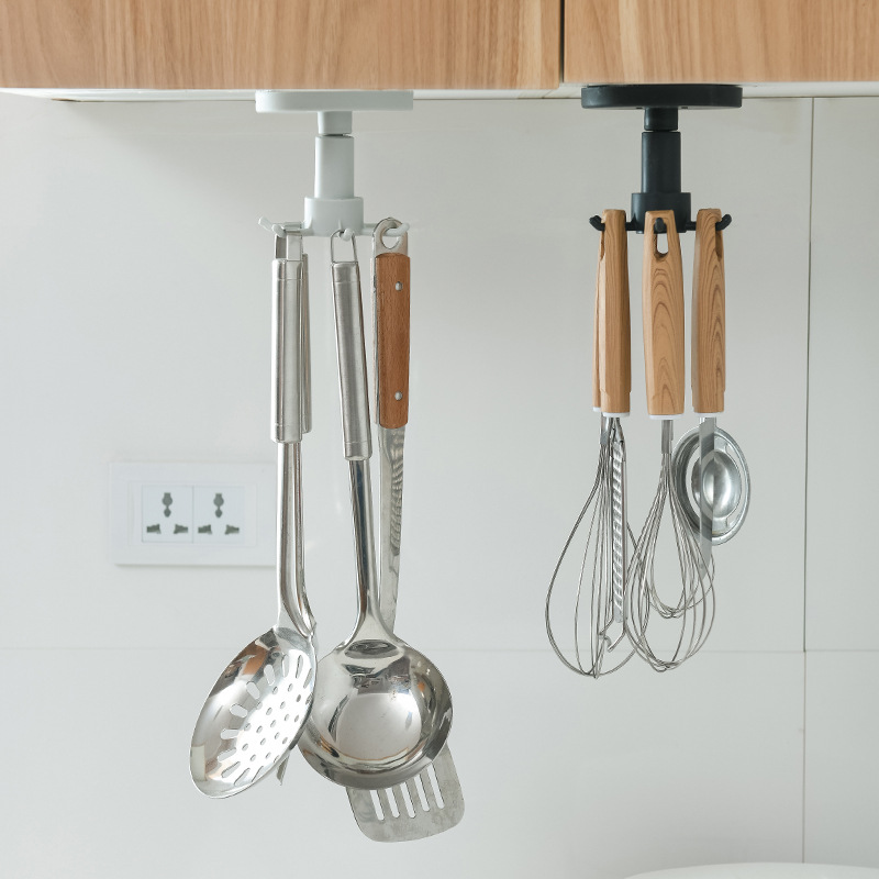 Under-cabinet rotating utensil rack holding ladles, a slotted spoon and whisks