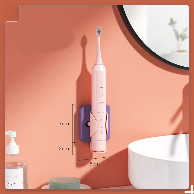 Pink toothbrush sitting in a purple wall holder with dimensions marked