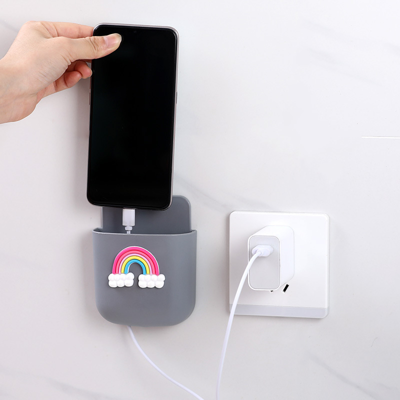 Hand placing a phone into grey rainbow wall pocket with charging cable