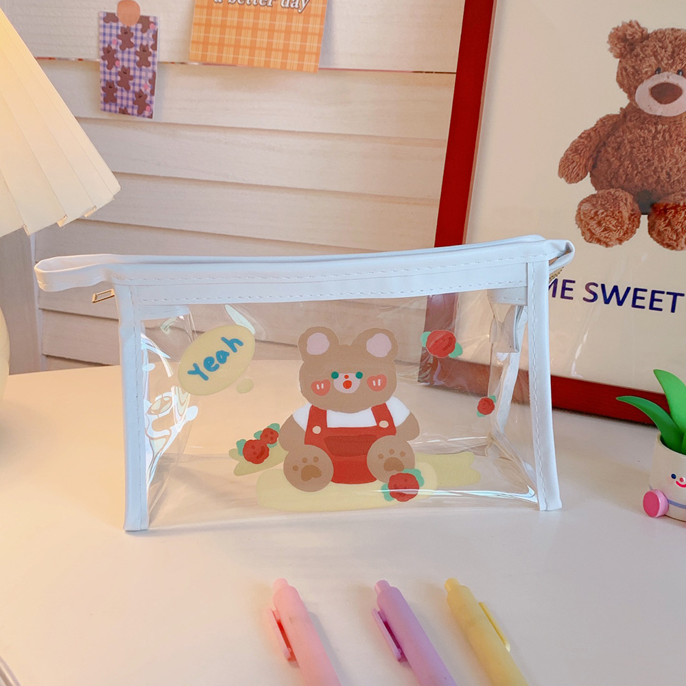 Side view of red bear pouch showing depth and clear panel on white desk