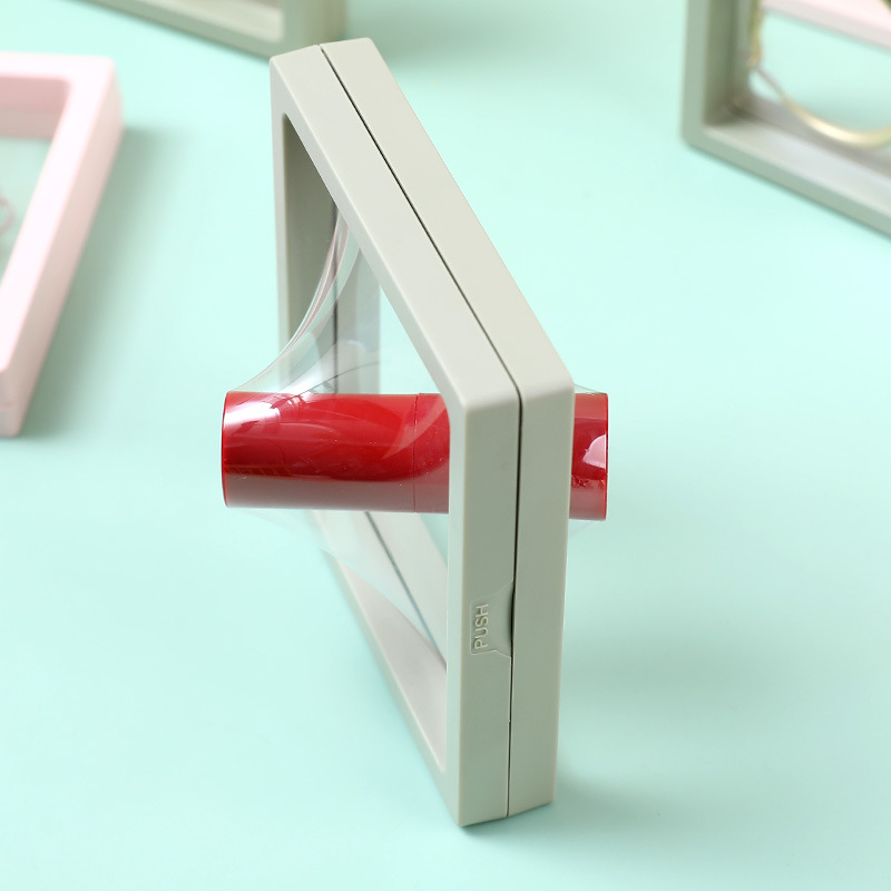 Side view of a grey frame with a red push latch on the edge