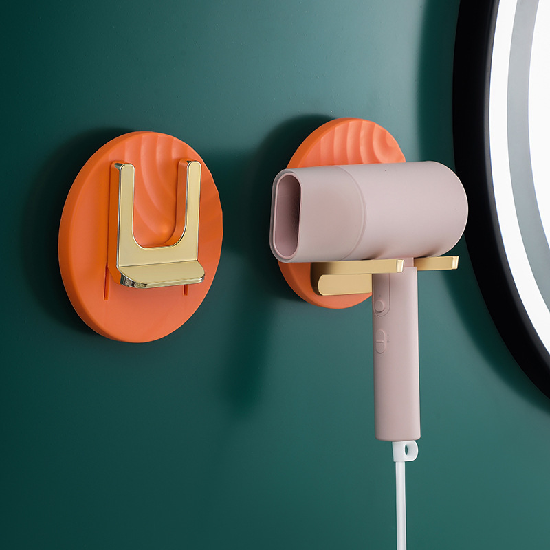 Orange holder on a green wall with the dryer hanging by its nozzle
