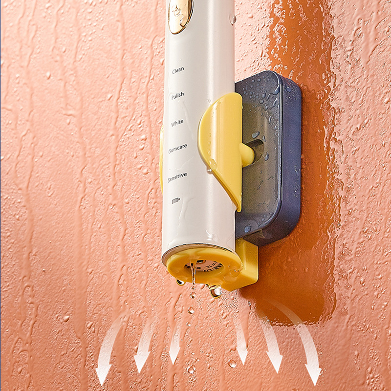 Water droplets running down the wall beneath a navy and yellow toothbrush holder