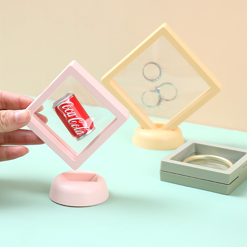 Pastel frames on round stands holding rings and a bangle on a table
