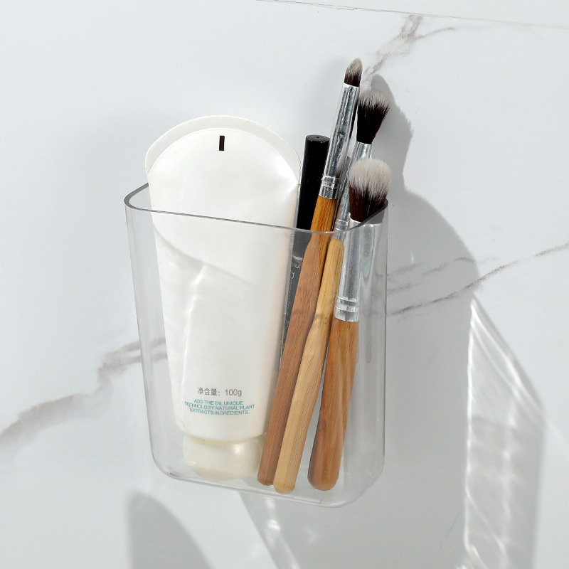 Single clear wall pocket holding a tube, makeup brushes and a lip pencil