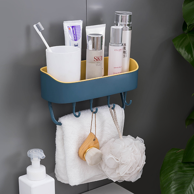 Navy wall rack with toothbrush cup, skincare and a hanging towel in a bathroom