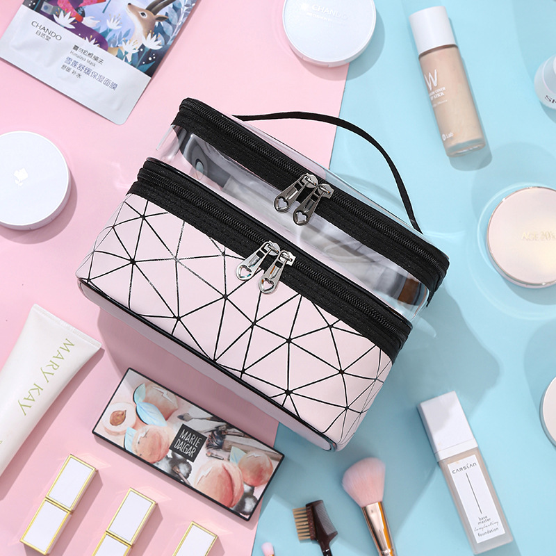 Pink geometric cosmetic bag with two zippered tiers and black carry handle on pastel background