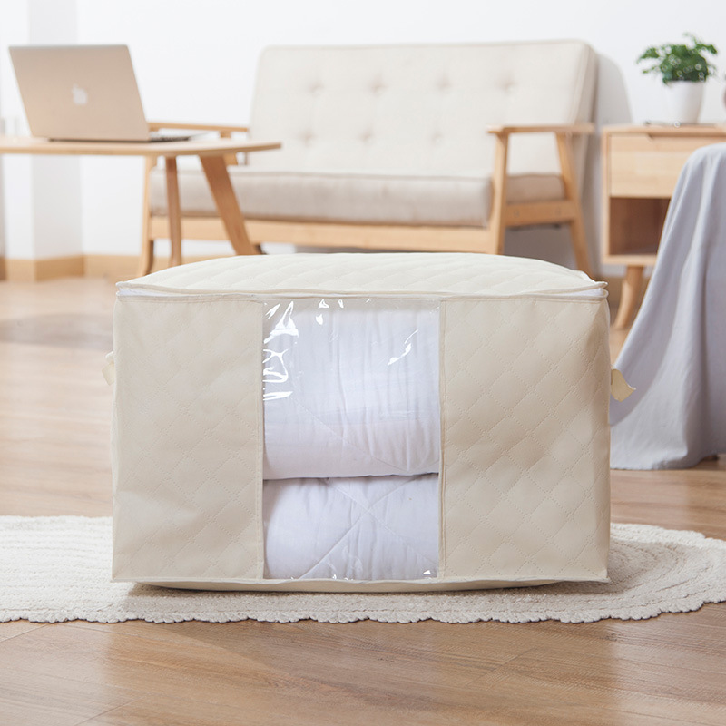 Quilt being rolled on a bedroom floor before storage