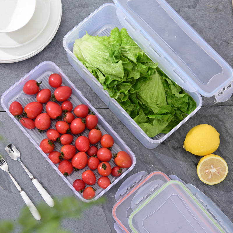 Clear fridge box with drain tray and secure lid closure on a table