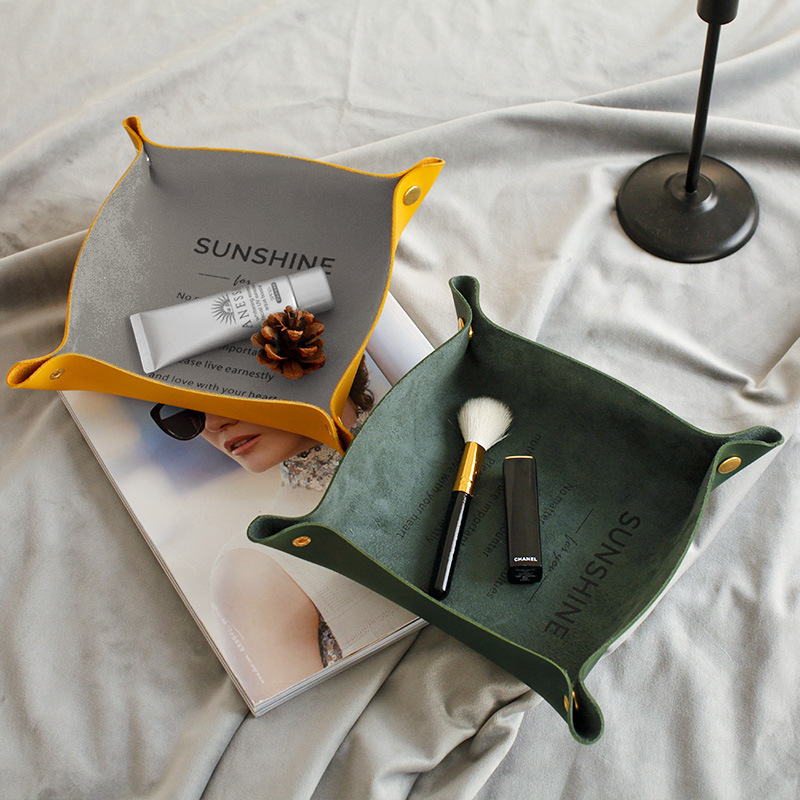 Leather-look tray on a desk holding small everyday items