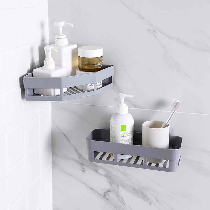 Grey corner rack with shampoo pumps and a cream jar on the slatted base