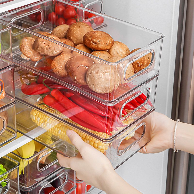 Hand pulling a clear bin out of a stacked fridge drawer system