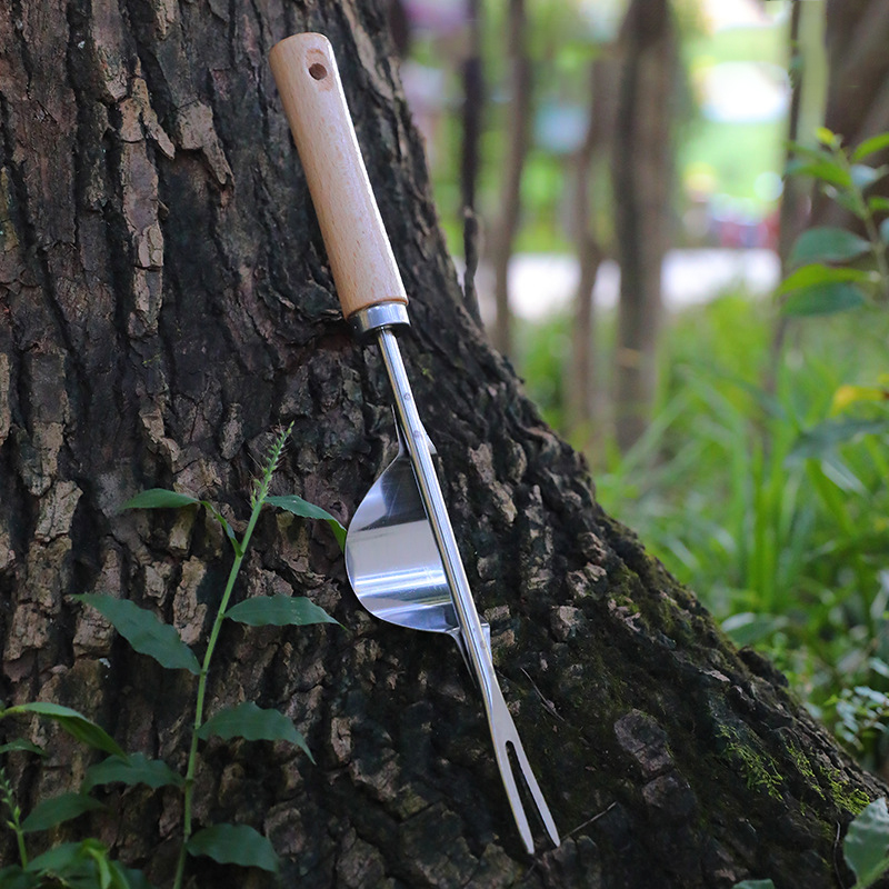 Tool leaning on a tree trunk showing the scoop curve and fork tines