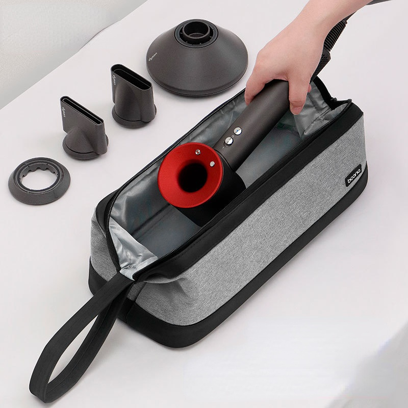Grey and black storage bag open with hair dryer and attachments inside