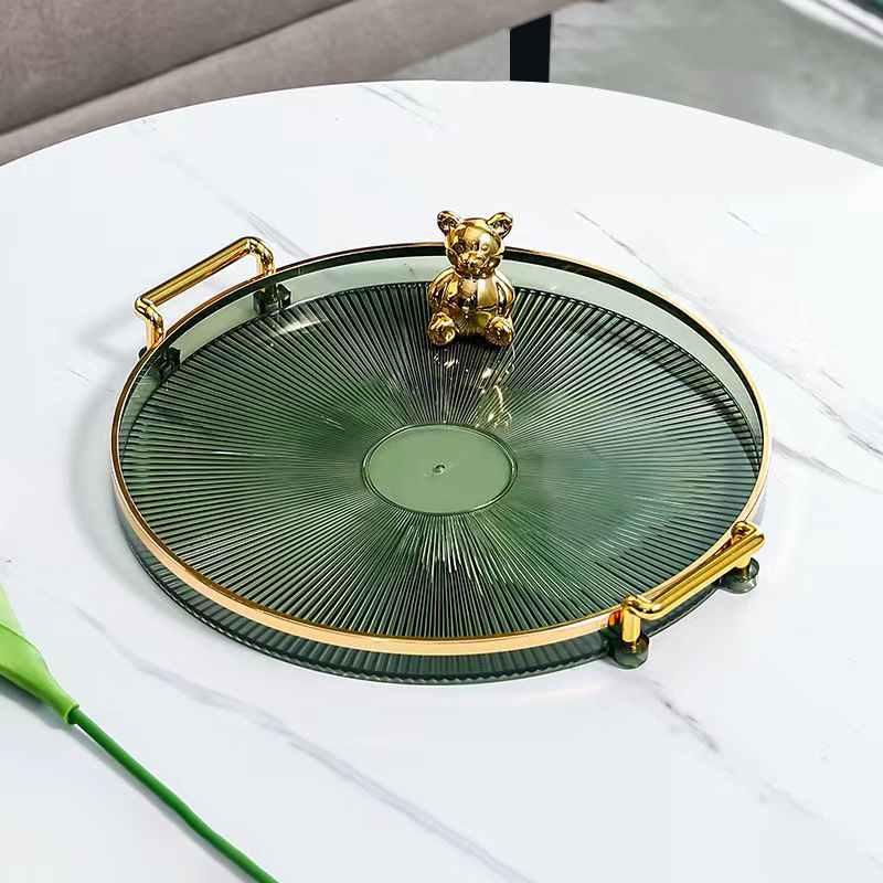 Round tray with gold-tone side handles on a light surface