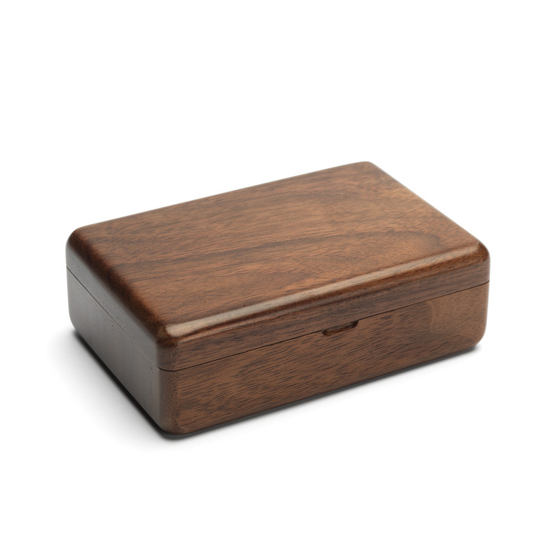 Walnut jewelry box with lid open showing the mirror on a dresser