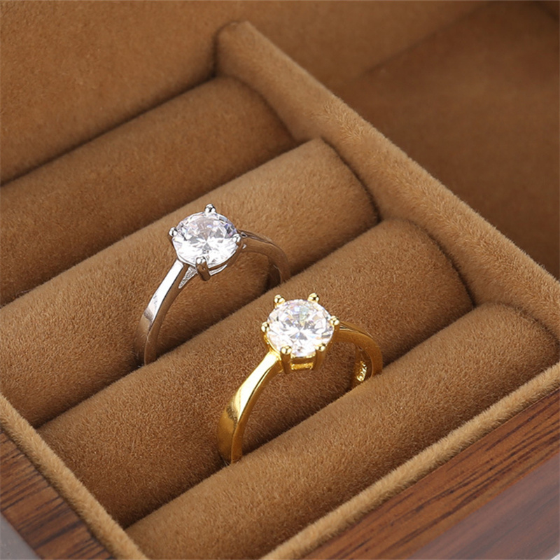 Gold and silver solitaire rings resting in individual velvet ring slots