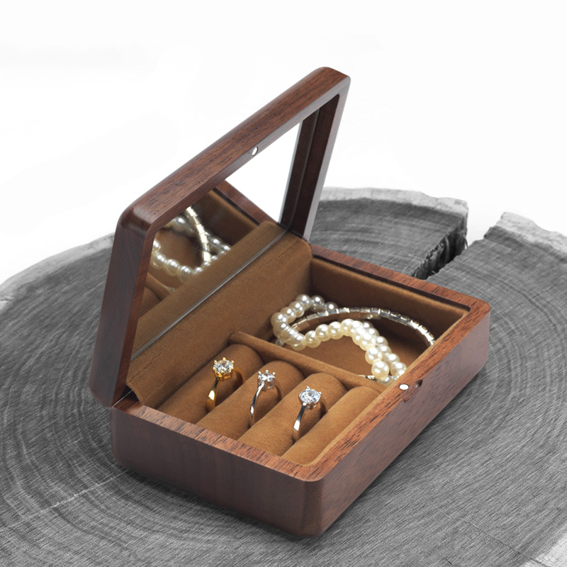 Pearl bracelet and necklaces lying flat in the open walnut compartment