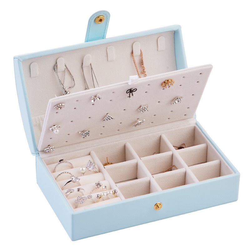 Light blue jewelry box lid with earrings pinned to the board