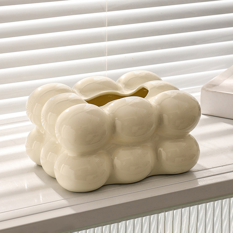 Cream glossy ceramic bubble tissue box cover on a window sill