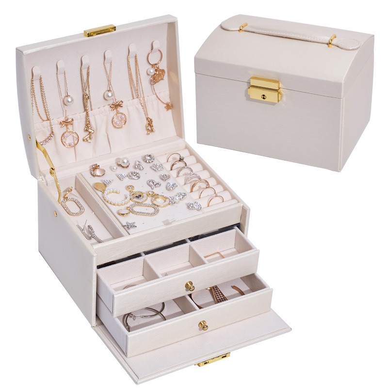 Open jewelry box with necklaces hanging from top tray hooks