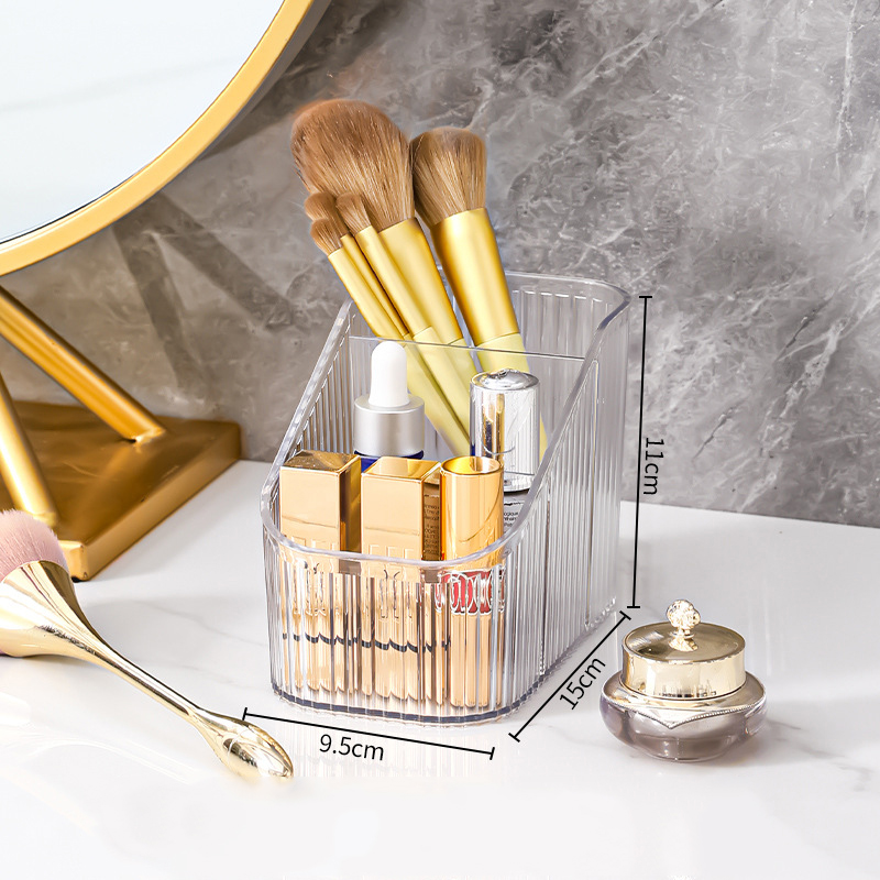 Compact clear ribbed box holding makeup brushes and lipsticks on a counter