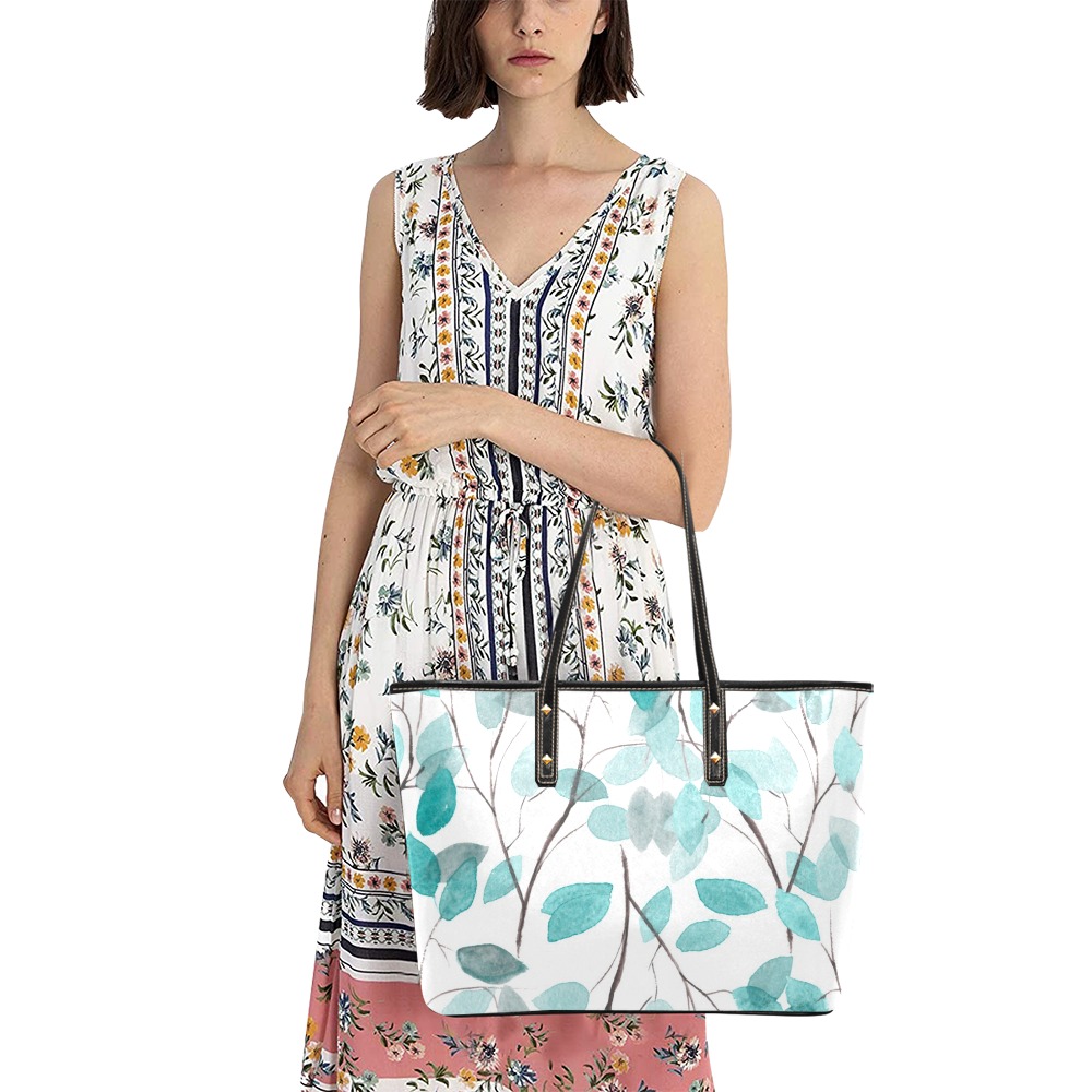 Woman carrying a PU leather tote bag with a teal floral print, perfect for school or travel