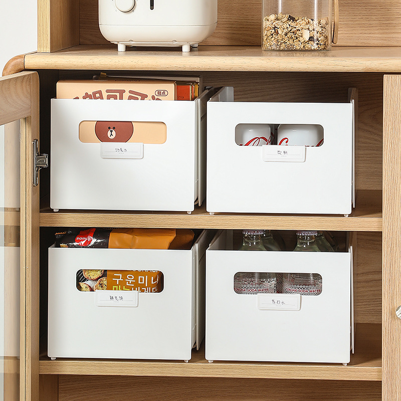 White storage bins with side cutout grips on a wooden kitchen cabinet