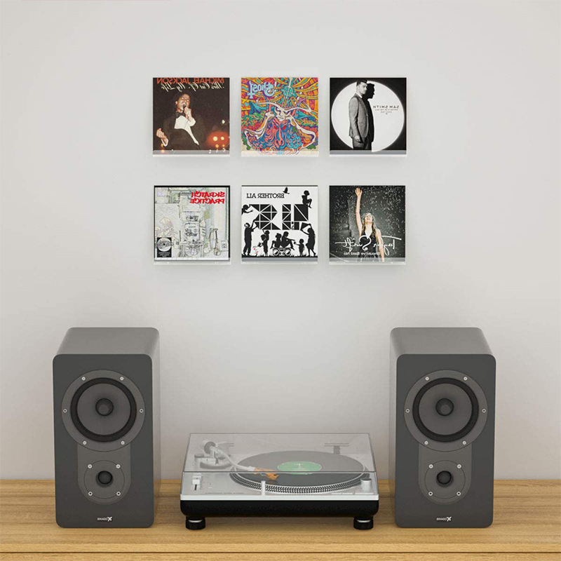 Album covers standing upright on clear acrylic shelves above a turntable in a living room