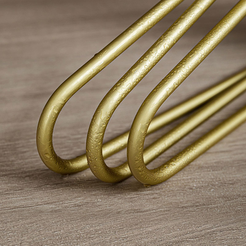Gold hangers arranged in a tidy row inside a styled wardrobe