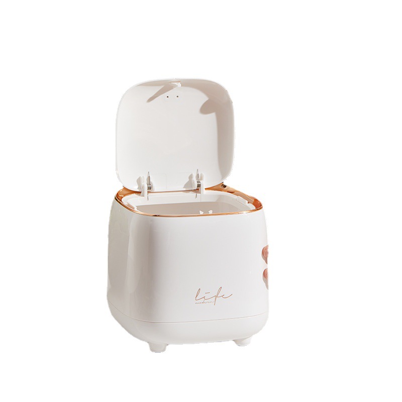 Compact square trash can set beside a tabletop in a small room