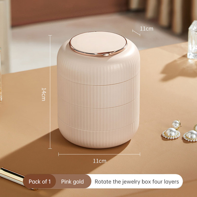 Pink gold blush rotating jewelry box sitting on a dressing table