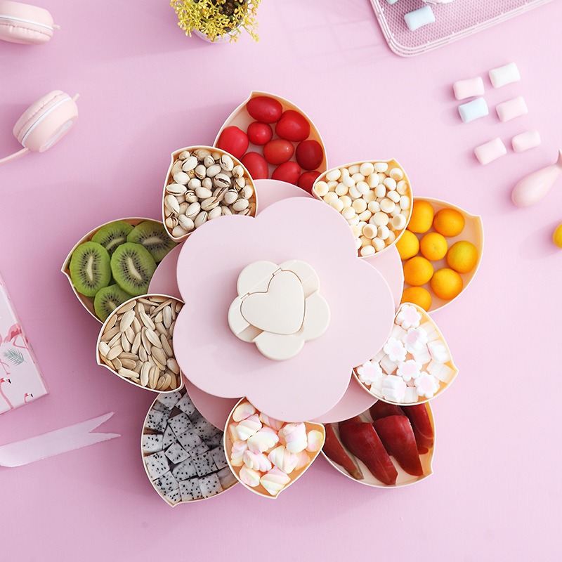 Top-down view of petal compartments filled with pistachios, kiwi, candy and dried fruit