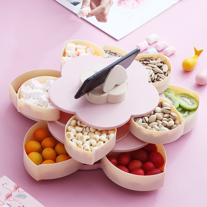 Lotus snack tray on a pink table with a phone resting against the lid