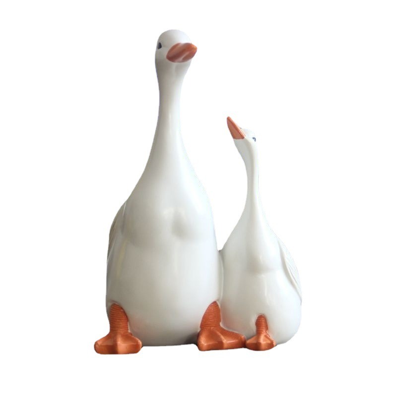 Two white ceramic ducks with copper-orange feet standing side by side