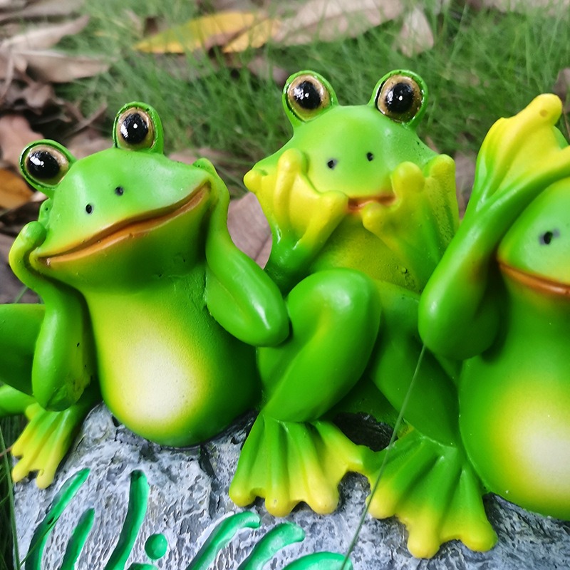 Close view of the frogs showing painted expressions and fine facial detail