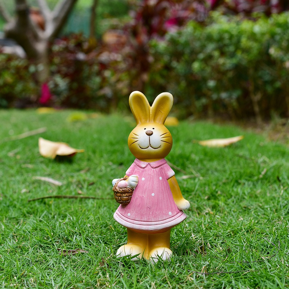 Girl bunny in pink dress with egg basket standing on green lawn