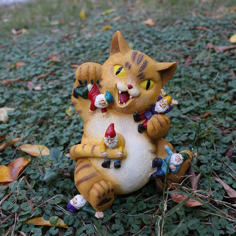 Resin cat statue set aside while a bare garden corner waits for it