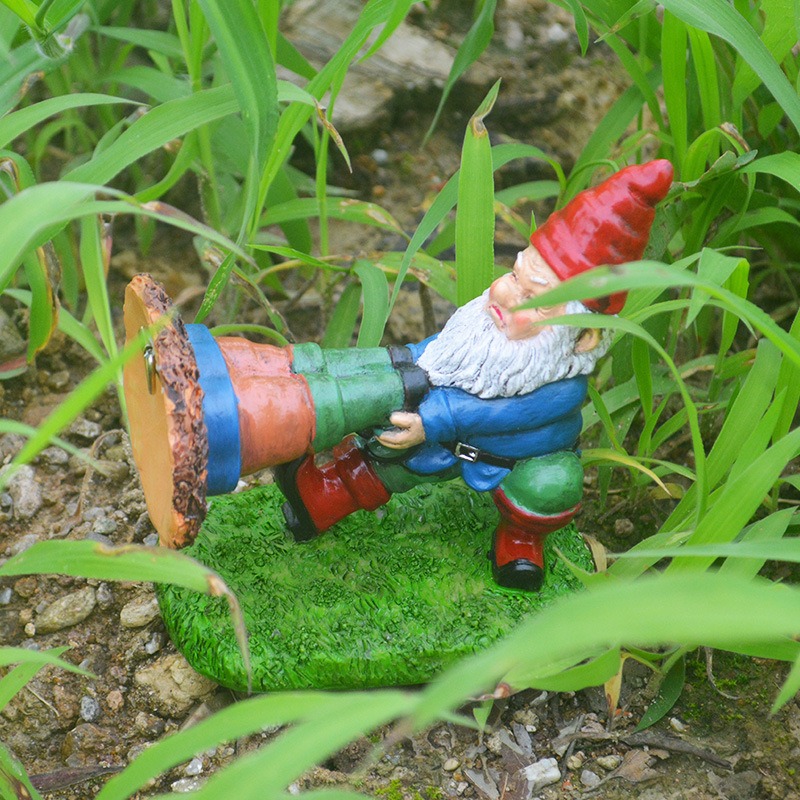 Gnome figurine set among green grass and soil in a garden