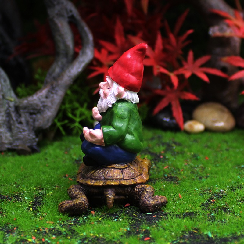 Mossy miniature landscape with red maple leaves and a seated resin gnome