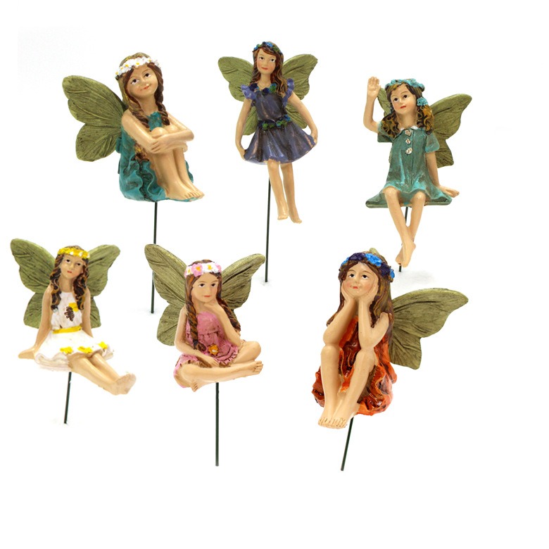 Fairy figures seen from several angles showing sage green wings