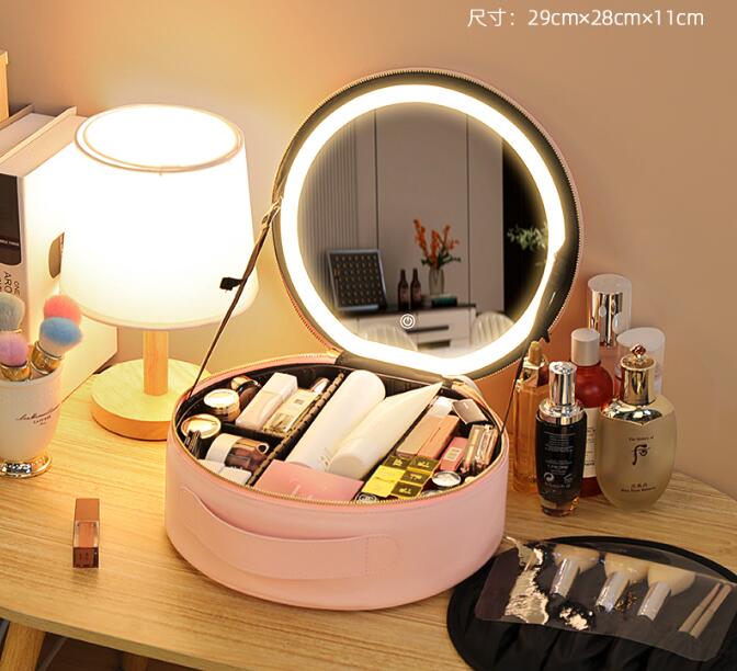 Makeup case and loose brushes on a bathroom counter in dim light