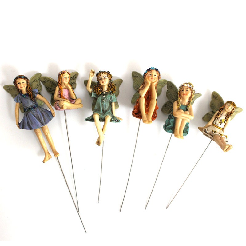 Thin metal wire stakes holding resin fairies ready for soil