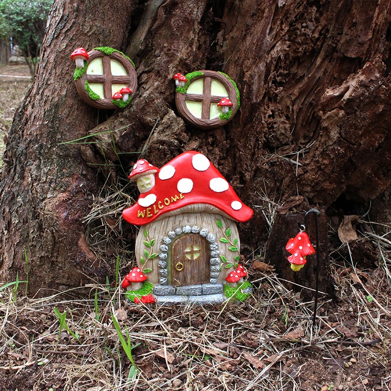 Fairy house windows and cottage mounted on an outdoor tree trunk