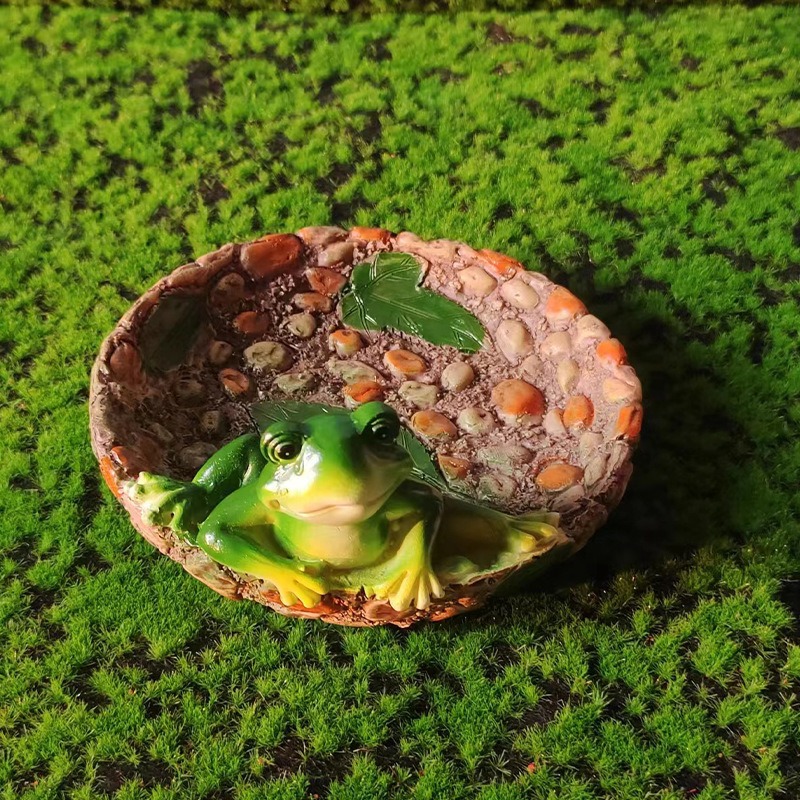 Frog tray set outdoors on green moss turf as a garden accent