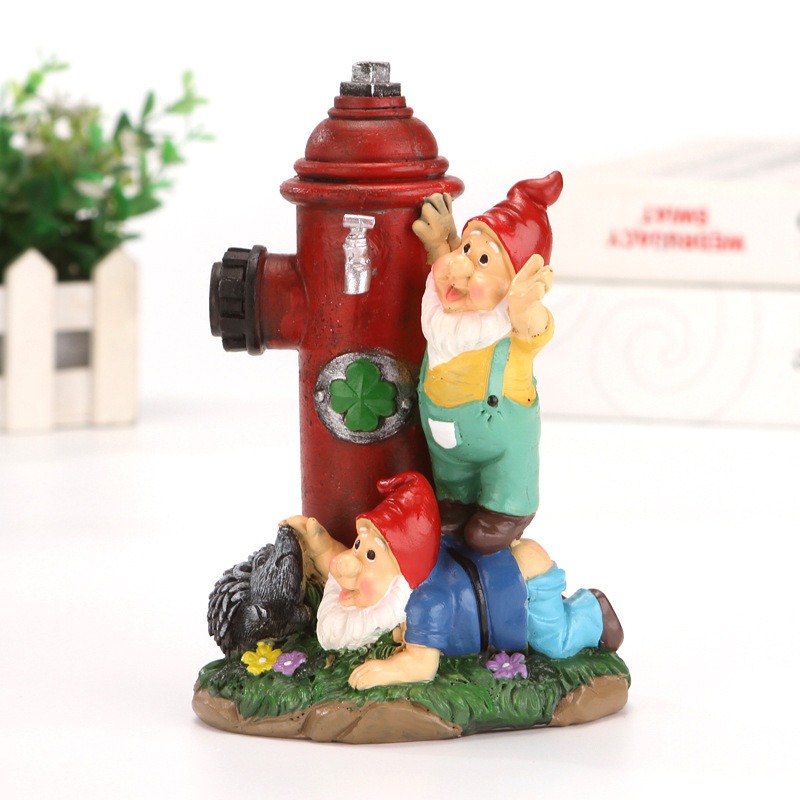 Gnome hydrant figurine set beside a white planter fence and green plant