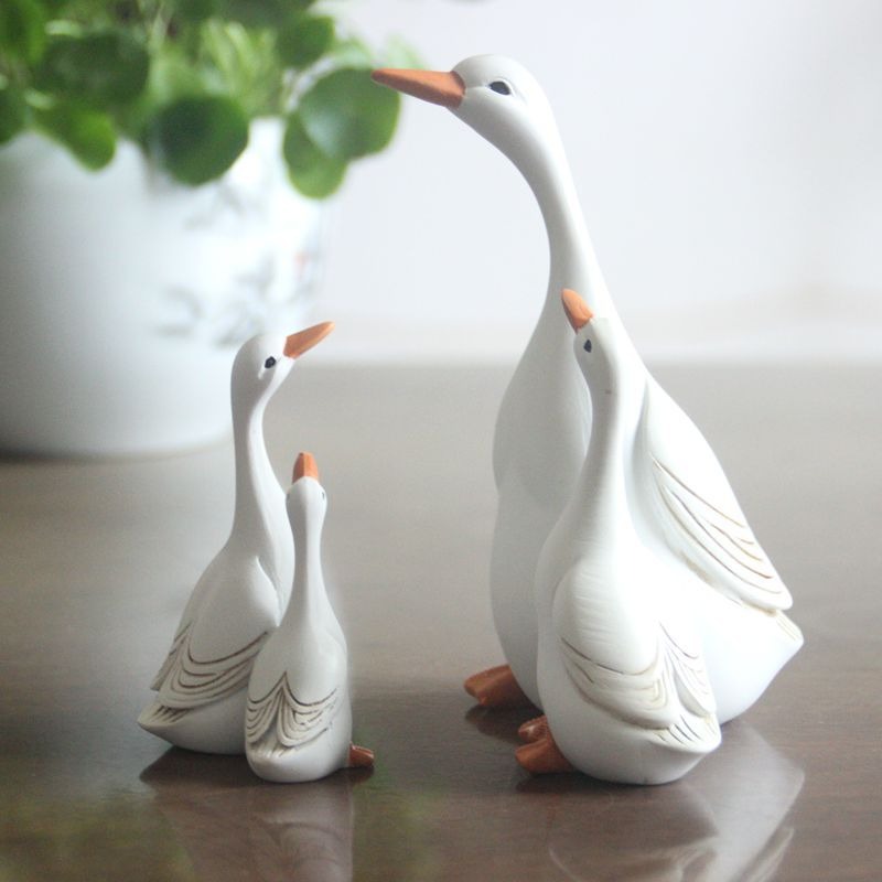 Glossy white duck pair placed along a garden border edge